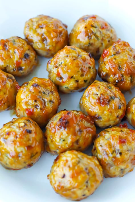 These Baked Spicy Chicken Meatballs are easy to make, healthy, and loaded with flavor! They’re also extremely juicy, great for meal prep, and are a fantastic party appetizer when tossed in a sticky, sweet and spicy Thai Sweet Chili Peanut Sauce! #chicken #meatballs #bakedspicychickenmeatballs #easychickenmeatballs #mealprep #healthymeatballs #bakedmeatballs | That Spicy Chick Spicy Chicken Balls, Korean Potluck Dishes, Spicy Chicken Meatballs, Spicy Baked Chicken, Resepi Biskut, Spicy Meatballs, Chicken Meatball Recipes, Chicken Balls, Sauce Chicken