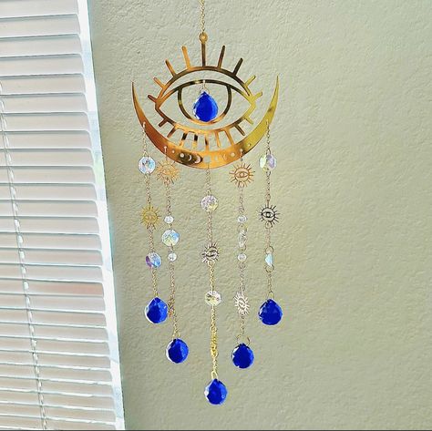 👁️【 Evil Eye Decor 】-- The evil eye suncatcher is made of evil eye and blue crystal ball. It brings you good luck and protects you from bad energy used to expel from your body the negative energy that envious people emanate. 👁️【Blue Crystal Ball 】- The evil eye suncatcher is absolutely beautiful. the crystal ball with amazing power. When the sun shines on the suncatcher, It will catch the light and make rainbows dancing around your room and heal your day. so happy and relaxed. Well worth it! ? Boho Hanging Decor, Moon Window, Prism Rainbow, Cosmic Design, Rainbow Dance, Crystal Wind Chimes, Crystal Hanging, Bad Energy, Indoor Window