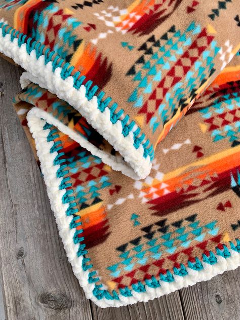 This Crochet Edge Native American Style Fleece Blanket is crafted with our top-quality fleece and an artisanally hand-stitched crochet edge by April. Enjoy the soft and fluffy comfort of fleece while adding a classic native design to your home. Available in four different edge options:1. Serged Edge2. Hemmed Edge3. Crochet Blanket Stitch4. Deluxe Crochet StitchApproximate Sizes (hemmed sizes are a bit smaller):BABY 30"x 38"MEDIUM 52" x 60"LARGE 72" X 60"PERSONALIZATIONYou may personalize your blanket. I screen print your name choice (two words maximum) in font style #1 on my reproduction grain sack fabric. If you desire a different font, please refer to the picture showing font styles and specify the style number along with the name in the notes upon checkout.BLANKET CAREWash and dry on de Native American Blanket Pattern, Western Crochet Blanket, Crochet Blanket Edges Ideas, Southwest Style Living Room, Fleece Blanket Ideas, Western Crochet, Fleece Blanket Edging, Native American Inspired Fashion, Native Blanket