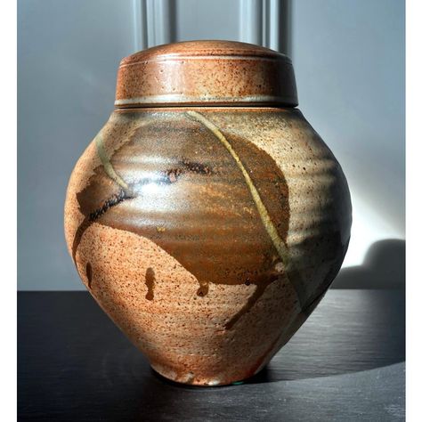 A ceramic (earth ware) lidded jar with glazed surface by American studio potter Karen Karnes (1925-2016). The mark on the jar indicates that the piece was made circa 2000s. The wheel-thrown piece shows off a beautiful form with a swell body and harmonious proportion, reminiscent of the vernacular jars one would find in Asian kitchens for fermenting and storage. The surface is covered with an orange color shino-like glaze and painted with abstract strokes, which clearly inspired by Japanese Minge Lidded Container Ceramics, Lidded Ceramics, Lidded Pottery, Moon Jar, Sun Burn, Pottery Jar, The Jar, Ceramic Jars, Ceramic Studio