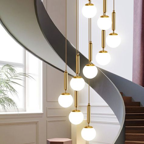 The "Minimalist Ball Pendant Lighting White Glass Stairway Multi Hanging Light Fixture in Gold" is a beautiful and stylish light fixture that is perfect for hanging in stairways, hallways, or any other living space in your home. This fixture features a white glass globe shade with a Gold metal body. It includes a 79" chain/cord and is 79" in height. The shade is 6" in height. This light fixture requires 6, 9, or 12 lights (not included). It is also available in a silver finish. The product is a Glass Stairway, Stairway Lighting, Gold Globe, Ball Pendant Lighting, White Pendant Light, Metal Hanging Lights, Hanging Light Fixtures, Ball Pendant, Outdoor Wall Lamps