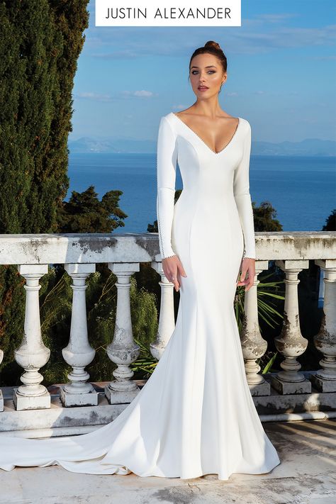 All eyes will be on you in this crepe long sleeve gown. It features a pearl seam detail down the sleeves, along the wrists and at the neckline. A clean V-back with pearl buttons down the train create this stunning wedding day look. This style is also available without the pearls along the sleeves. Justin Alexander Bridal, Justin Alexander Wedding Dress, Plain Wedding Dress, Long Sleeve Wedding Gowns, Trumpet Wedding Dress, Justin Alexander, White Wedding Dress, Long Sleeve Gown, Classy Aesthetic