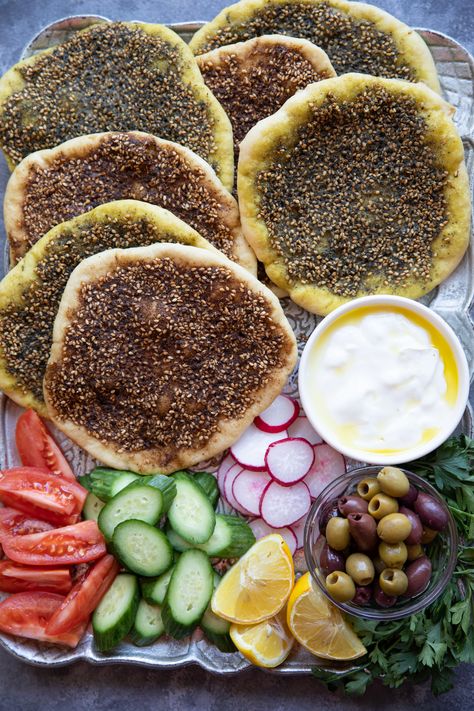 Manakish zaatar is a classic Middle Eastern flatbread topped with olive oil and zaatar spice. Zaatar is a combination of spices and has a wonderful earthy flavor. This bread is so easy to make and is perfect for breakfast with some cheese! Learn how to make this simple Middle Eastern vegan bread with just a few ingredients, you're going to love it! Dinner Party Middle Eastern, Middle Eastern Feast, Middle Eastern Brunch Ideas, Middle East Breakfast, Zaatar Sandwich, Middle Eastern Dinner Party, Zaatar Bread Recipe, Manakish Recipe, Turkish Mezze