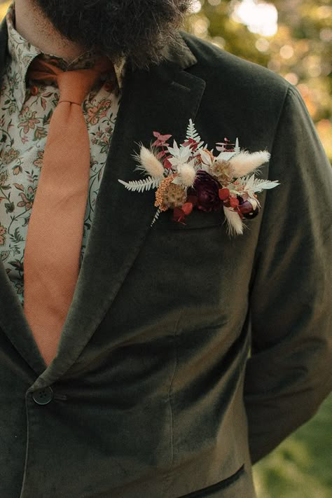 Groovy 70s Gardens Wedding Center Wedding | Junebug Weddings Rustic Wedding Tuxedo, Mens Unique Wedding Attire, Unique Men’s Wedding Outfit, Mens Floral Wedding Attire, Alternative Wedding Suits Men, Emerald Western Wedding, Cottagecore Groomsmen, Cottage Core Groom Suit, Dark And Moody Groom Attire