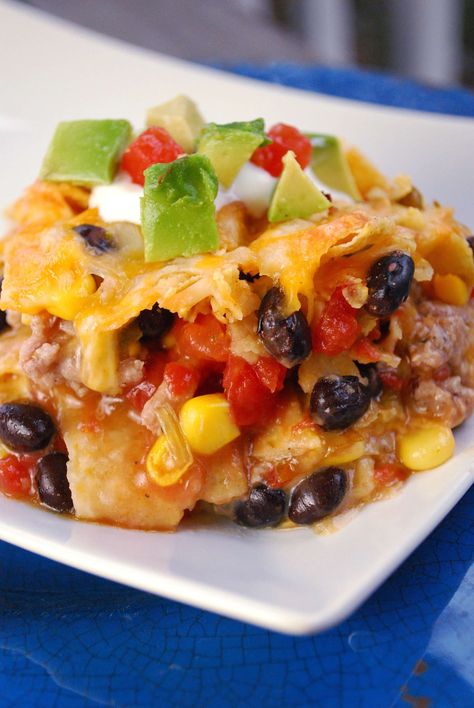 This easy nacho casserole is loaded with beef, black beans, cheese and green chili sauce. Kid friendly recipe for a quick weeknight dinner idea! Easy Beef Nachos, Nacho Casserole, Chili Nachos, Easy Taco Casserole, Easy Mexican Casserole, Baked Nachos, Beef Nachos, Green Chili Sauce, Easy Nachos