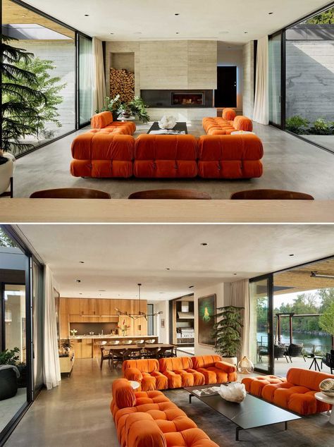 In the living room, bright orange couches face both the fireplace and the river view, as well as being open to the courtyard. Bright Open Living Room, Living Room Orange Couch, Orange Couch Living Room Ideas, Orange Couches, Orange Couch Living Room, Partially Covered Patio, Concrete Floors Living Room, Orange Lounge, Living Room Bright