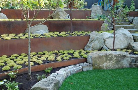 If you’re using planters near vegetable, avoid toxic lead as they can cause damage Steel Retaining Wall, Boulder Garden, Boulder Retaining Wall, Retaining Wall Design, Terraced Landscaping, Landscaping A Slope, Northwest Landscaping, Garden Retaining Wall, Sloped Yard