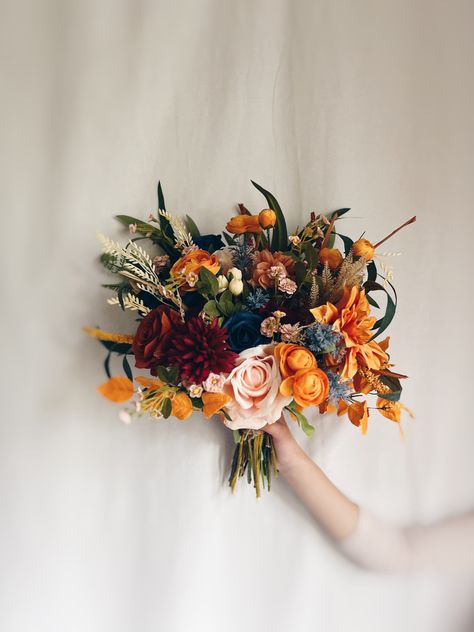 "This lovely silk wedding bouquet is made from faux flowers of navy blue, rust orange , terracotta, pale pink and light cream, sage greenery, silk eucalyptus, faux pampas. They will make the perfect addition to your big day!  This bridal bouquet consists of silk roses, peonies, ranunculus, hydrangeas and dahlias, green silk eucalyptus and sage greenery and fillers. The stems are wrapped in twine. The bridal bouquet pictured is 16\" (41 cm). Matching bridesmaids bouquets, toss bouquet, corsages a Navy Blue Flowers Wedding, Orange And Blue Wildflower Bouquet, Navy Blue And Rust Wedding Bouquet, Terracotta Blue Wedding, Blue And Orange Bouquet, Flowers Moodboard, Terracotta Bouquet, Navy Blue Wedding Bouquets, Elopement Florals