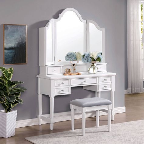 You'll love getting ready in the morning with this old Hollywood-inspired solid wood vanity set. Complete with a tall, tri-fold mirror, this inspired vanity set boasts a gleaming white finish punctuated with glittering, crystal-look knobs on multiple drawers. An included light gray upholstered stool adds a plush, comfortable spot to settle as you choose jewelry, apply makeup or put the finishing touches on your hairstyle. Tri Fold Mirror Vanity, Beachy Vanity, Beautiful Vanities, Vanity Desks, Vanity Goals, Wooden Makeup Vanity, White Homes, Triple Mirror, White Vanity Set