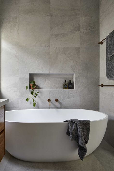 This modern en-suite bathroom has a single vanity with a glass-enclosed walk-in shower on one side and a freestanding bathtub with a shelving niche on the other. Bathtub With Niche, Tub And Shower Side By Side, Window In The Kitchen, Deck For Entertaining, Modern Ensuite, Pass Through Window, Bathroom Freestanding, New House Bathroom, Bathroom Layouts