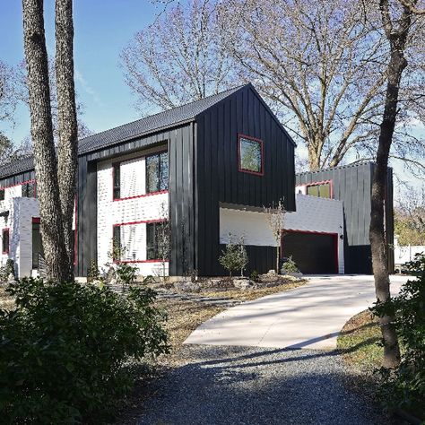 BlauHaus seamlessly marries gabled and flat roof sections, united by an elevated roof deck. The exterior is clad in a combination of cementitious siding and standing seam metal panels adorned with striking red accents. Inside, the space is a sanctuary from the bustle of daily life, bathed in natural light pouring through window walls, featuring bamboo floors, and vibrant red accents echoing the exterior. Window Walls, Bamboo Floors, Standing Seam, Roof Deck, Metal Panels, Flat Roof, Red Accents, Daily Life, Roof