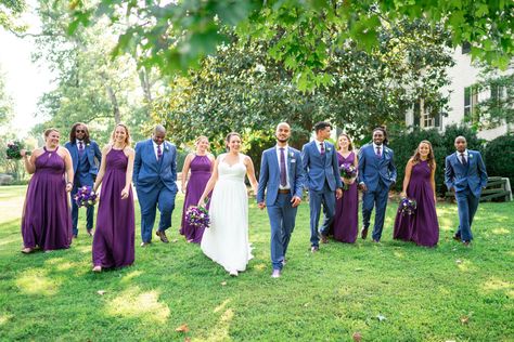 Bride and groom and bridal party walking photo at Rust Manor House in plum purple bridesmaid dresses and blue suits with purple ties Purple Bridesmaids Blue Groomsmen, Blue Suit Purple Tie Wedding, Purple And Blue Wedding Party, Blue Suit Purple Tie, Purple And Blue Wedding, Rust Manor House, Blue Wedding Colors, Dark Purple Bridesmaid Dresses, Blue Groomsmen Suits