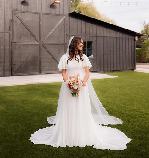 Awwww, this beautiful bride is a vision in our Jill gown!! We’re so happy you chose to wear one of our modest wedding dresses for your romantic ring ceremony! Congrats @halleigh.powers !! @a_dressy_occasion Chiffon + lace make up this romantic A-line gown worn by @halleigh.powers for her ring ceremony! 💍🤍✨ Our MERRIWAY dress comes with either flutter sleeves or bishop sleeves but you can, of course, customize with any type of sleeve you desire! Available in 3 different color schemes: Ivory,... Wedding Dress With Butterfly Sleeves, Wedding Dress With Butterfly, Square Neck Wedding Dress, Ring Ceremony, Romantic Rings, Her Ring, Modest Wedding, Modest Wedding Dresses, A Line Gown