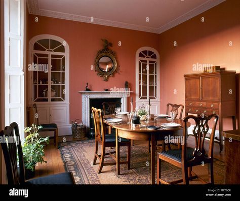 Download this stock image: Traditional dining room with terracotta colour walls, wood side cabinet, oval dining table and chairs, and arched, built-in china cabinets flanking a - MFT6CR from Alamy's library of millions of high resolution stock photos, illustrations and vectors. Terracotta Dining Room, Modern Crockery, Crockery Cabinet Design, Terracotta Walls, Dining Room Colour Schemes, Built In China Cabinet, Crockery Cabinet, Dining Room Paint Colors, Cabinet Designs