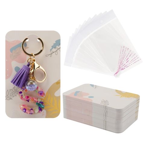 PRICES MAY VARY. PACKAGE INCLUDES - 100 x Keychain Display Cards, 100 x Self-Sealing Bags. PRODUCT SIZE - Each cards measures 3 x 4.7 in/7.5 x 12 cm, each clear bags measures 3.5 x 5.5 in/9 x 14 cm. HIGH QUALITY - Our keychain place cards are made of quality art paper with pre-cut holes, which is not only sturdy and durable, but also not easy to bend and break. These cards are thick enough to be written and not easy for ink to pass through. UNIQUE DESIGN - This keychain card is improved and desi Keychain Display, Cards Holder, Packaging Supplies, Cute Keychain, Clear Bags, Display Cards, Amazon Art, Jewelry Packaging, Sewing Stores