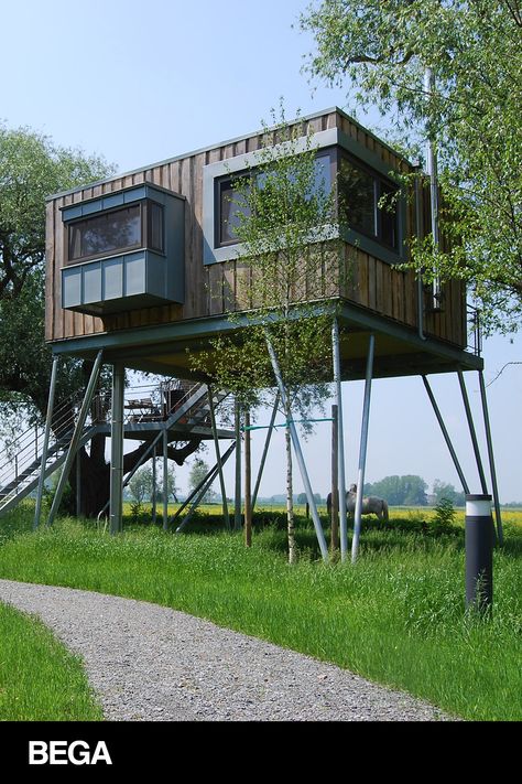 This modern tiny home design is raised on stilts, and provides wide-reaching views of the surrounding nature. Engineered wood paneling combined with metal elements create a modern tree house impression. Learn more about the luminaires featured in this project at bega-us.com. Tree House Aesthetic, Modern House On Stilts, Raised Homes, Cabin On Stilts, Platform House, Modern Tiny Home, Drawing Room Decoration, Stilt House, Modern Tree House