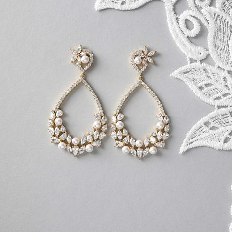 These earrings feature a teardrop-shaped hoop adorned with a charming cluster of pearls, pear, and marquise cut CZ jewels on the lower half. Boasting a length of 2.25 inches, these earrings have titanium post backs and are crafted from rhodium or gold plated brass with AAA CZ stones. Plus, they are lead, nickel, and cadmium free for a worry-free and luxurious accessory. #wedding #earrings #earringshop #earringstyle #earringslover #earringstagram #earringsaddict #earringsforsale #earringsofth... Teardrop Bridal Earrings, 2025 Wedding, Black And White Earrings, Weaving Ideas, Bridal Accessories Jewelry, Gold Bridal Earrings, Bride Accessories, Jewellery Ideas, Hot Nails