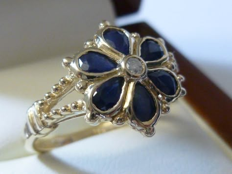 9CT/9K SOLID GOLD NATURAL SAPPHIRE & GENUINE DIAMOND FLOWER RING This beautiful Vintage inspired ring has been crafted in 9ct Solid Yellow Gold Each bezel set petal of this Floral ring has a NATURAL Sapphire and an Earth Mined prong set Diamond in the centre (COLOUR: G & CLARITY: SI). The wishbone shoulders have been beautifully decorated. THIS VINTAGE INSPIRED SAPPHIRE/DIAMOND BLOSSOM RING IS TRULY AN EXQUISITE FINE JEWELLERY PIECE WHICH IS TO BE TREASURED FOR A LIFETIME * FREE GIFT BOX Sapphire Flower Engagement Ring, Antique Sapphire Ring, Victorian Rings Vintage, Sapphire Flower Ring, Diamond And Sapphire Ring, Diamond Flower Ring, Vintage Sapphire Ring, Vintage Inspired Rings, Vintage Sapphire