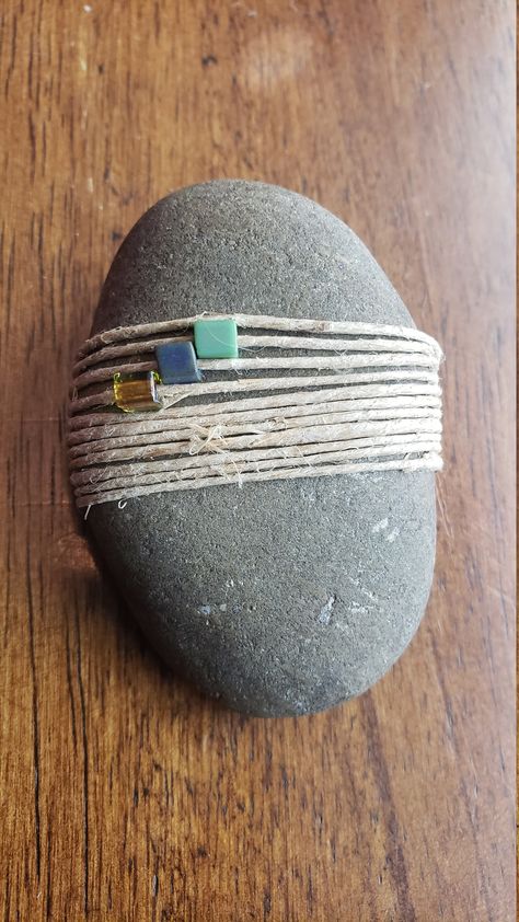 Tiny beads wrapped with natural polished hemp. Weaving On Rocks, Wrapped Rocks Tutorial, How To Wrap Rocks, How To Display Rocks, Rock Garden Art, Light Library, Diy Stone Wrapping, Rock Weaving, River Rock Crafts