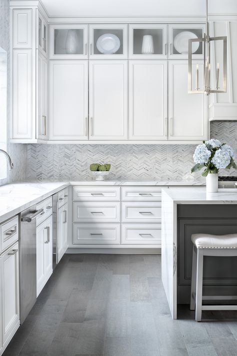 Large farmhouse u-shaped medium tone wood floor with an undermount sink, recessed white panel cabinets against a gray stone tile backsplash, with stainless steel appliances, and a large white quartz island. Stone Tile Backsplash, Modern Farmhouse Interior Design, Grey Kitchen Floor, Gray Floor, Large Farmhouse, Gray And White Kitchen, Modern Farmhouse Kitchen, White Kitchen Design, White Countertops