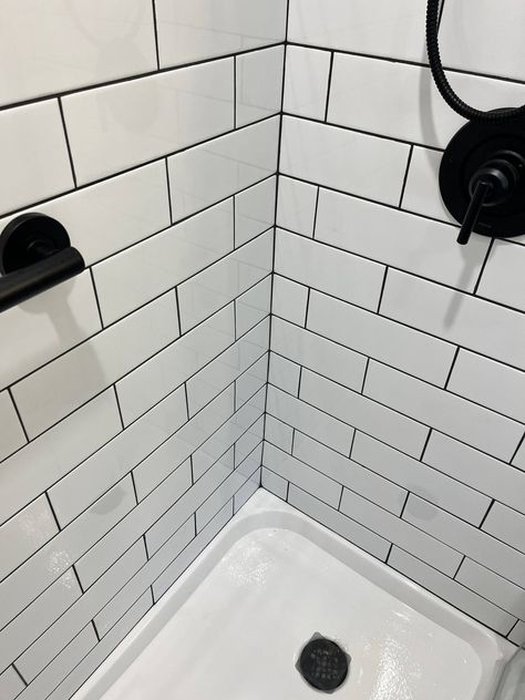 We love how this clients bathroom came out! The white subway tile is such a classic look, but the black grout lines and fixtures give it a bold & modern feel. #transitionaldesign #longislandcontractor #bathroomremodel White Subway Tile Shower Black Grout, White Tiles Black Grout Bathroom, White Tiles Black Grout, White Shower Tile, White Subway Tile Shower, Black Subway Tiles, Bathroom 2024, Bathroom Upstairs, Subway Tile Showers