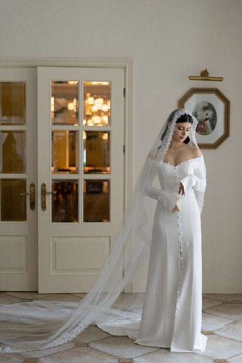 We’re positive that the classy wedding dress you’ve been dreaming of is somewhere on this list! Look through our collection of elegant wedding dresses--like this off-the-shoulder long sleeve button detail gown--to find your timeless bridal look. White Dress With Buttons, Off Shoulder Long Sleeved Wedding Dress, Long Sleeve Romantic Wedding Dress, Twilight Wedding Dress Inspiration, Romantic Elegant Wedding Dress, Bridal Dresses Simple Elegant, Long Sleeve Off The Shoulder Wedding Dress, Romantic Off The Shoulder Wedding Dress, Off Shoulder Long Sleeve Wedding Dress