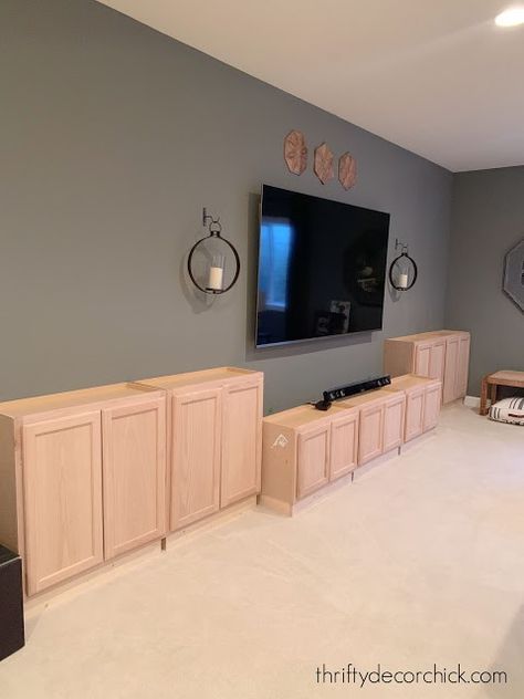 Diy Cheap Built Ins, Rustic Wall For Tv, Unfinished Cabinets Entertainment Center, Basement Tv Built In Wall Units, Diy Built In Entertainment Center Plans, Diy Entertainment Wall With Fireplace, Basement With Half Wall Ledge, Tv Built In Wall Unit Diy, Diy Entertainment Built In