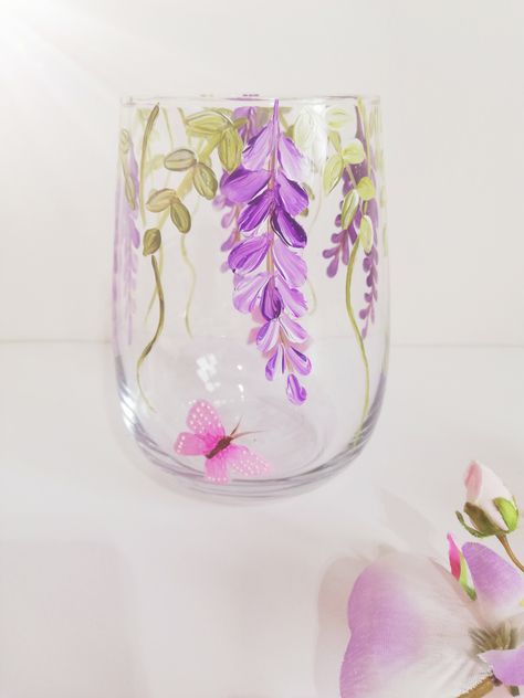 The stemless glass has been hand painted with glass enamel in an eye catching wisteria design in a choice of either purple or burgundy.with soft flowing leaves and swirls. The glass style is so versatile, it can be used as a glass for your favourite drink, a pretty tealight holder, a small vase or all three as its dishwasher friendly. It has been baked in the oven to seal and is top drawer dishwasher safe.. The glass stands at 12.5cm high and holds 590ml. Lavender Glass Painting, Flower Bottle Painting, Candle Jar Painting, Jar Painting Aesthetic, Jar Art Paint, Glass Painting Aesthetic, Glass Jar Painting Ideas, Glass Flower Painting, Glass Vase Painting Ideas