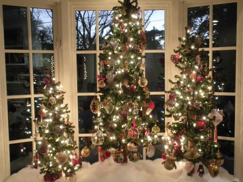 Three Christmas Trees In One Room, Christmas Decor Ideas Bay Window, Christmas Tree Bay Window, Bay Window Christmas Decorations, Bay Window Holiday Decor, Bay Window Christmas Tree, Christmas Bay Window Ideas, Decorating A Bay Window For Christmas, Christmas Tree In Bay Window