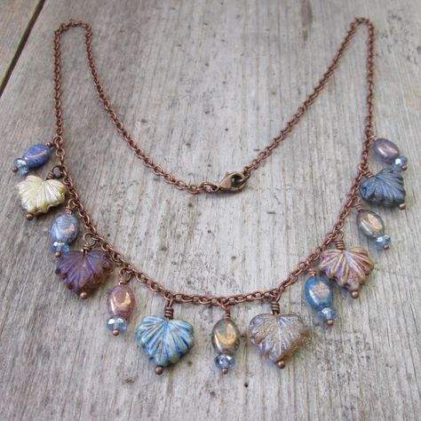 Crafted with meticulous attention to detail, each necklace, bracelet, and earring in this Mixed Maple Series is a stunning fusion of rustic boho charm. At the heart of every design are the Czech maple leaf beads, adorned in a mesmerizing array of silky metallic blue, purple, cream, and earthy browns. Accentuating the maple leaves are oval beads with a bronze luster finish, mirroring the hues found in the leaves. Interwoven in most items are round beads, rondelle, and metal bead caps each one unique in shape and texture. This listing is for the hanging leaf necklace, as shown in the first few photos. Designed to be worn short, it is offered 16" or 18." I am happy to add an extender chain if you ask. This is available in copper or antique brass. Hanging from it are the 11x13mm leaf beads sep Diy Statement Necklace, Diy Jewelry To Sell, Earthy Jewelry, Beaded Jewelry Necklaces, Art Necklaces, Leaf Jewelry, Beaded Wraps, Leaf Necklace, Diy Pendant