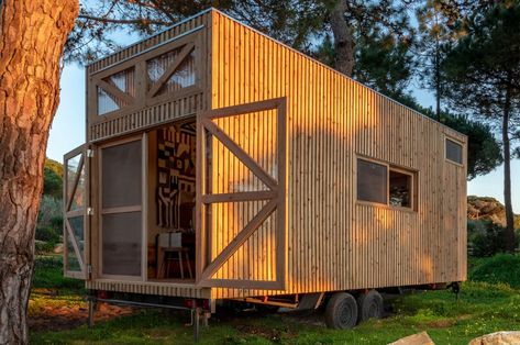 This off-grid tiny home on wheels finds space through simplicity with an open-plan interior that's entirely paneled in wood. Portuguese carpentry and architecture studio Madeiguincho is known for its catalog of tiny homes, treehouses, interior furnishings, and sculpture work. The team’s latest off-grid tiny home is built atop four wheels that allow residents to take Design Casa Piccola, Off Grid Tiny House, Shelter Design, Appartement Design, Rain Water Collection, Yanko Design, Tiny House On Wheels, Off Grid Living, Sustainable Architecture