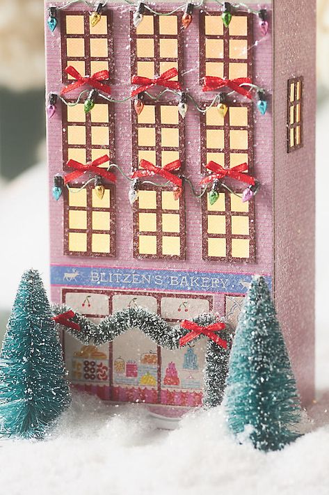 Unwrap the season with our Holiday 2024 collection, where magic meets merriment. Inspired by holiday villages found in London, Paris, and a little bit of old Toronto, each delicately crafted paper house captures the whimsy and festivity of the holiday season. | x Anthropologie Light-Up Holiday Village Paper House by Emily Taylor in Pink, Polyester/Plastic Anthropologie Christmas Houses, Anthropologie Christmas Village, Pastel Christmas Village, Christmas Paper Houses, Paper Christmas Houses, Putz Houses Display, Anthropology Christmas, Christmas Anthropologie, Diy Christmas Village Houses