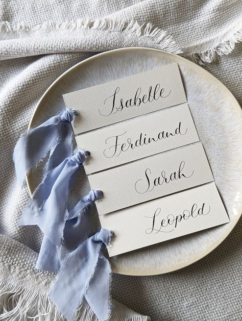 Handwritten calligraphy place cards for your special day | wedding | baptism | birthday | family celebration | baby shower and much more. Elegant, modern, personal place cards/name cards with the first name of your guests. Each place card is unique and is handwritten by me with lots of love, using pen and ink. A great appreciation for each guest that will be remembered. FORMAT 5cmx15cm MATERIAL * matt black ink * high-quality, structured 300g/m² watercolor paper * airy soft chiffon silk ribbon i Winter Place Cards, Name For Wedding Table, Wedding Guest Cards Table, Winter Wedding Name Place Cards, Wedding Seat Place Cards, Calligraphy Place Cards Wedding, Handmade Place Cards, Classic Wedding Place Settings, French Blue Wedding Theme