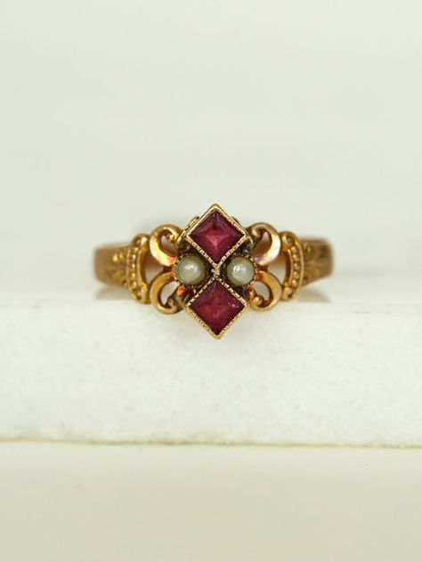 Her dainty Victorian style with gold work scrolls frame a powerful pair of Pearls and two stacked Rubies, set in a 10k gold band.  She's a fine addition to your collection.      	Ladies Size 6  	10k Yellow Gold Band  	Two Ruby red stones, pearls  	Arrives in gift box  Exclusively from Erin Pelicano Curated Vintage Collection. Each piece is intentionally chosen, pre owned, and ready to be loved and cherished again. sold as shown.  Shop the Curated Vintage Collection Vintage Stone Rings, Victorian Rings Engagement, Vintage Rings Antiques, Pearl Jewelry Aesthetic, June Rings, Antique Engagement Rings Victorian, Vintage Gemstone Rings, Victorian Wedding Ring, Vintage Ruby Ring