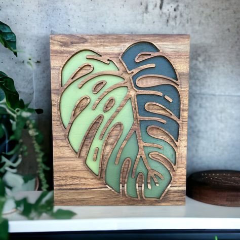 This beautiful Monstera leaf is carved in sturdy, heavy Teak wood, stained in an Early American style and then hand-painted with a mix of perfectly blended leaf greens. This piece of art is perfect for gifting or elevating any area! Hang it or lean it against any wall to liven any area of your home. It is 11in wide, 14in tall and 1 in thick. Includes a D Ring Hook on the back. Watch how we make this beautiful piece: https://www.instagram.com/p/C8fkW6fPOWZ/ Monstera Wall, Jungle Decorations, Early American Style, Jungle Wall, Wood Wall Art Diy, Wood Painting Art, Wood Mosaic, Leaf Wall, Wall Art Design