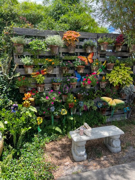 outside sitting area with butterfly statues and potted plants as the backdrop. Hidden Sitting Area Garden, Arbor Sitting Area, Garden Hangout Area, Pretty Garden Ideas Backyards, Creative Yard Ideas, Diy Outdoor Sitting Area, Outdoor Corner Ideas, Outside Reading Area, Outside Sitting Area Ideas