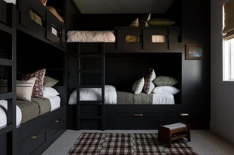 Bedroom features L shaped black built in bunk beds with forest green bedding, a black bunk bed ladder and a brown gingham rug with small wooden stool. Moody Lake House, Black Lake House, Black Bunk Beds, L Shaped Bunk Beds, Bunk Bed Ladder, Bunk Beds Built In, Light And Dwell, House Light, Built In Bunks