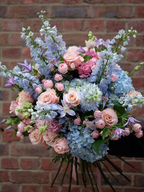 Pastel blush of pink spray roses mixed along side beautiful large heads of pearl coral colour rose and Ice blue delphinium. Including an enlightening range of light blue hydrangea complementing the fluffy tutu shape of Lisianthus and finishing with the touch of lilac colour clematis. Refreshing, colourful and perfect in spring or summer. Image shows size: Statement The flower bouquet will be wrapped in a complimentary wrapping and a bouquet bag with water. To include a vase with your bouquet, kindly select one from our Vase Collection. We kindly request that you order this bouquet at least 1 day in advance to ensure we hand-pick the finest flowers for you. Lilac And Blue Bouquet, Yellow Pink Blue Flower Arrangement, Pastel Flowers Bouquet, Colorful Hydrangea Bouquet, Pink And Powder Blue Wedding, Colourful Flower Arrangements, Blue And Pink Flower Arrangements, Pink And Blue Flower Arrangements, Blue And Pink Bouquet