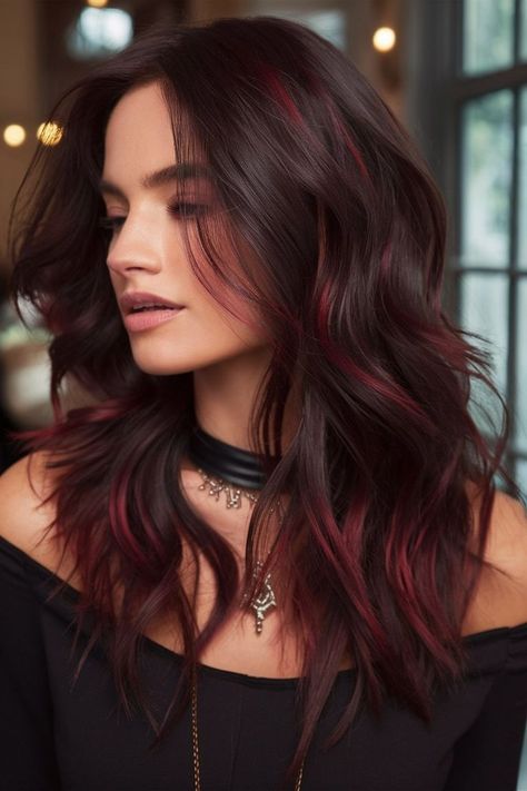 For those looking to make a bold statement, this edgy dark hairstyle features vibrant red highlights subtly blended into wavy layers. The contrast between the deep base color and the bright red accents creates a striking look that’s perfect for those with a daring sense of style. Ideal for adding a pop of color without overwhelming the overall look, this hairstyle offers a fresh and youthful vibe. Vibrant Red Highlights, Bright Red Highlights, Dark Waves, Red Hair With Highlights, Wavy Layers, Temporary Hair Dye, Dark Red Hair, Bright Red Hair, Red Highlights