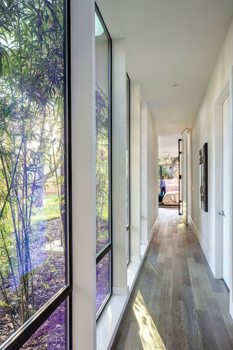 This modern hallway with floor-to-ceiling windows connects the master bedroom with the rest of the house. L Shaped House Plans, L Shaped House, Modern Family House, Casa Country, تصميم للمنزل العصري, Long Hallway, Modern Hallway, Big Windows, Hus Inspiration