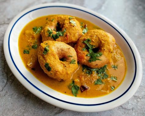 Medu Vada is a South Indian delicacy which is made by frying Urad Dal. It is a doughnut shaped fritter which is soft & fluffy on the inside and crispy on the outside. It is generally enjoyed as breakfast along with Sambar and Chutney. Sambar Vada, Indian Savouries, Medu Vada Recipe, Medu Vada, Vada Recipe, Upma Recipe, Veg Biryani, Dum Biryani, Urad Dal