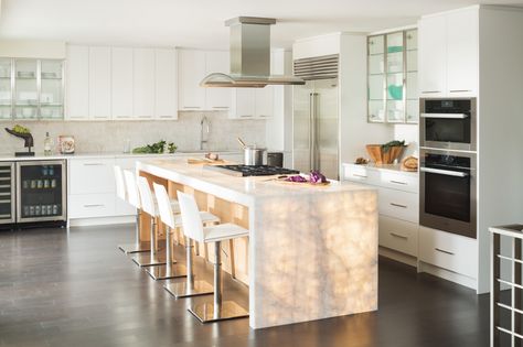 Nothing is more stunning than this backlit onyx kitchen island. LED panels were installed behind the translucent stone for a stunning waterfall island that makes a "glowing" statement. It provides a subtle but definitive focal point for a family that loves to entertain. Kitchen Island Entertaining, Glowing Island Kitchen, Glowing Kitchen Island, Light Up Island Counter, Backlit Kitchen Island, Statement Kitchen Island, Backlit Island, Onyx Kitchen Island, Onyx Kitchen Countertops