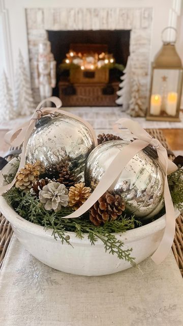 Jenny Brooks • Bloom Interior Designs on Instagram: "Easy centerpiece idea! ✨ And the best part is these fabulous oversized mercury ornaments are on sale for $15! Grab a large bowl, some greenery, 2 ornaments, pinecone filler, and ribbon…because bows make everything better! 🤍 I linked the ornaments and several bowl options for you. Just tap the link in my bio for details… #holidaycenterpiece #christmastabledecor #centerpiecesideas #christmasdecor #holidayhomedecor #christmascenterpiece #coffeetablestyling" Ornament Bowl Centerpiece, Candle Filler Ideas, Large Decorative Bowl Filler Ideas, Bread Bowl Decor Centerpieces Christmas, Bowl Of Ornaments, Ornaments In Bowl, Large Bowl Decor Ideas, Bowl Fillers Ideas Centerpieces, Christmas Dough Bowl Decorating Ideas