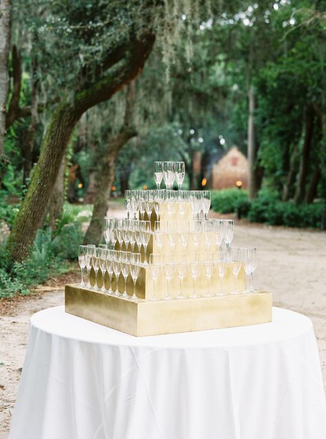 This gold display is a beautiful way to serve your bubbly for your wedding. Champagne towers are glamorous and make a statement at the entrance of your reception, and definitely a totally camera-ready. This is one of my favorite wedding Champagne tower ideas. Perfect for your cocktail hour and an elegant way to toast the newlyweds. Another ideas is to showcase your champagne glasses with your seating display. Place the escort cards directly on the glass for your guests, an elegant display. Wedding Entrance Champagne, Champagne Wedding Entrance, Champagne Toast Display, Champagne Glass Display Party Ideas, Champagne Table Display Wedding, Champagne Serving Ideas, Champagne Colored Wedding Decor, Cocktail Hour Drink Display, Ceremony Champagne Table