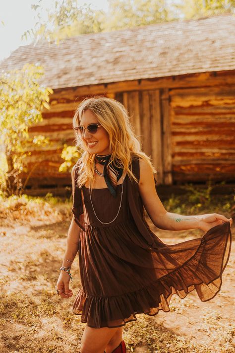 The Kayenta Dress is the perfect mix of western style and modern chic. With adjustable tie shoulders and baby doll style, it can be dressed up for a night out or dressed down with boots and a trucker cap for a more laid-back look. Make a statement in the Kayenta Dress! Sizing: Small 2-4, Medium 6-8, Large 10-12 Model's Measurements: Height 5'5 | Bust 32 | Waist 26 | Hips 36 | Size S Wedding Guest Dress With Cowgirl Boots, Country Cocktail Attire, Country Dresses With Cowboy Boots, Country Dresses With Boots, Long Dress With Boots, Western Wedding Outfits Guest, Western Wedding Guest Outfit, Dress With Cowgirl Boots, Country Western Dresses