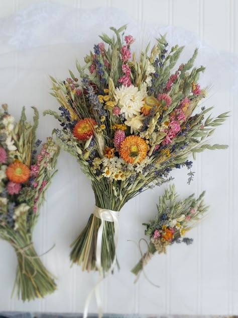 The Hippie Bouquet! One of my favorite designs! For the youthful, hippie-boho wedding! The bride's bouquet has strawflowers on both sides while the smaller bouquets are front facing. Pink and Fuschia Gomphrena, Lavender, Oats, Green Wheat, Grasses, Nigella Pods, Orange/Red and White Straw Flowers. Strawflowers are all unique.  Bouquets can come with lace wrapped stems or jute twine wrapped stems. Lace may be a little different than pictured. Boutonnieres are wrapped with hemp twine and pin on. The hairpiece is on bendable wire to hook into an up-do. Corsages tie on with hemp twine. The flower crown ties in the back with hemp twine, making it adjustable. Colorful Boho Bouquet, Boho Wedding Backyard, Hippy Wedding, Unique Bouquets, Dried Flower Wedding, Straw Flowers, Green Wheat, Bride's Bouquet, Hippie Wedding