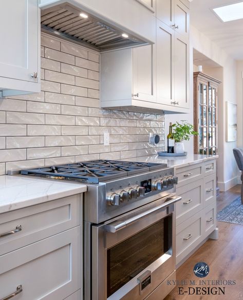 Warm gray painted kitchen cabinets, Brittanica Warm Cambria Quartz countertops, white marble look. Warm gray subway tile with dark grout, range hood, Fulgor stove #edesign #kylieminteriors #kyliemedesign #subwaytile #subwaytilebacksplash #cambria #graykitchen #graykitchencabinets Kitchen Subway Tile Black Grout, White Backsplash With Gray Grout, White Subway Tile Dark Grout Kitchen, 2x16 Subway Tile Backsplash, White Kitchen With Coloured Tiles, White Subway Tile Grey Grout Kitchen, White Subway Tile With Dark Gray Grout, White Subway Tiles With Grey Grout, White Subway Tile Kitchen Backsplash Black Grout