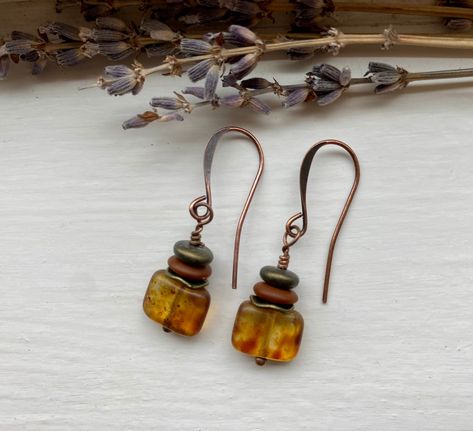 "oolong ~ earthy bohemian tortoise shell amber glass earrings with antique bronze, terracotta, dark olive green, and antique copper accents Details & measurements: ~ Gorgeous small rectangle Czech glass beads with an earthy Picasso finish, giving them a beautiful  tortoise shell look (12 x 8mm) ~ Accented with wavy antique bronze spacer beads (7 x 1mm), Czech glass rondelle spacer beads in matte terracotta (7mm), and Czech glass smooth flat spacer beads in metallic dark olive green (6mm) ~ Earrings hang from antique copper ear wires ~ They hang just under 1 1/2\" long ♡ Packaged safely & sustainably in a kraft box with cotton ribbon & dried organic florals. This makes for a beautiful gift, or something pretty for yourself! All packaging materials are zero waste and also reusable. ♡ As well Earth Tone Jewelry, Earthy Bohemian, Earthy Earrings, Paper Bead Jewelry, Earthy Jewelry, Cotton Ribbon, Bronze Earrings, Earrings Everyday, Copper Accents