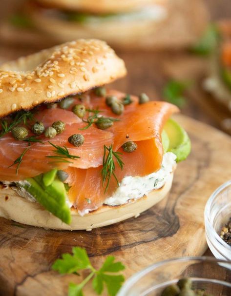 These Smoked Salmon Bagels are loaded with a homemade herb cream cheese, avocado and capers. They're easy to make and bursting with flavour! #bagels #salmon #lunch | www.dontgobaconmyheart.co.uk Salmon And Capers Bagel, Salmon Capers Cream Cheese, Bagels With Salmon And Cream Cheese, Salmon Bagels Smoked, Bagels With Smoked Salmon, Cream Cheese Sandwiches Recipes, Bagel With Smoked Salmon, Smoked Salmon On Bagel, Smoked Salmon Burger