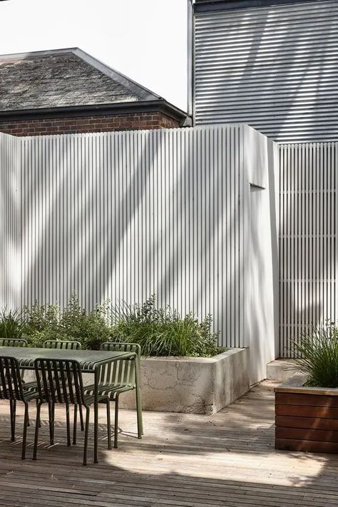 Picture of a tall white fence paired with a concrete raised garden bed with greenery and grasses are a cool idea for a modern space White Fence, Courtyard Design, The Local Project, Modern Beach House, Exterior Cladding, Hill House, Garden Bed, House On A Hill, Raised Garden